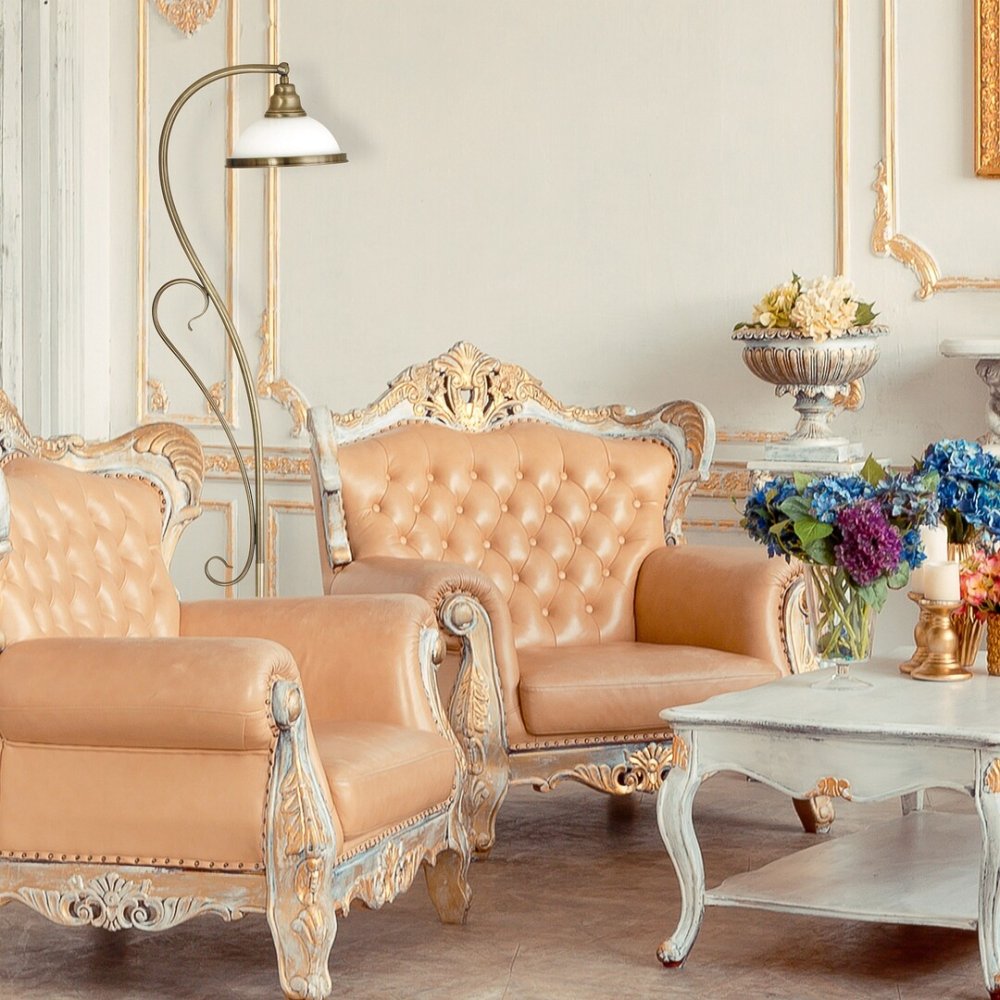 Rustikálna stojaca lampa s béžovým tienidlom, so zlatou kovovou tyčou a detailami umiestnená v rohu obývačky.