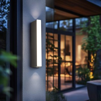 Vertikálne tenké čierne nástenné svietidlo na rohu modernej budovy osvetľuje stenu smerom nahor aj nadol.