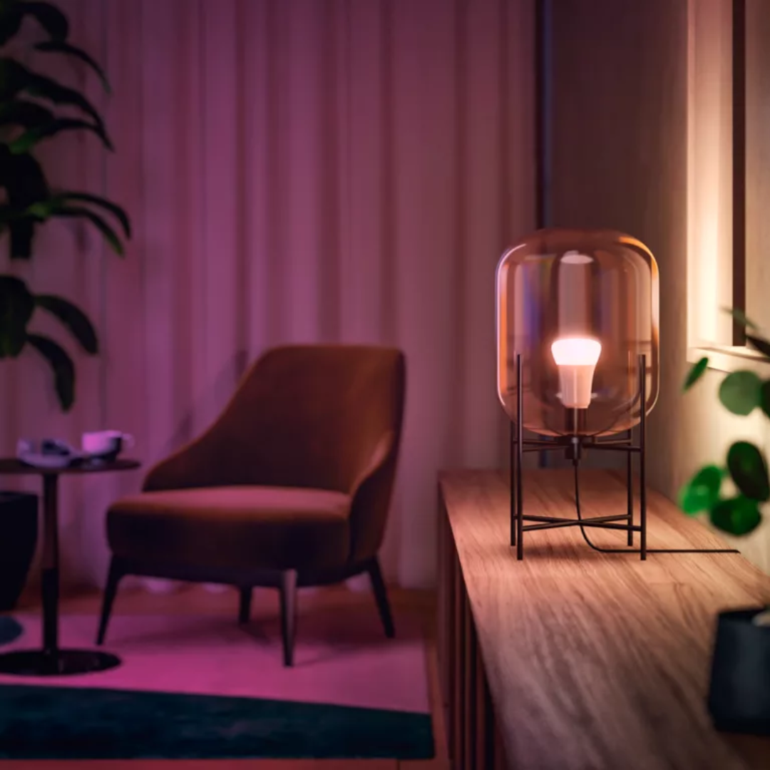 Smart zásuvka Philips Hue v obýváku. Detail retro lampy položené na dřevěné skříňce, která je proměněná na chytré svítidlo pomocí zásuvky Hue.